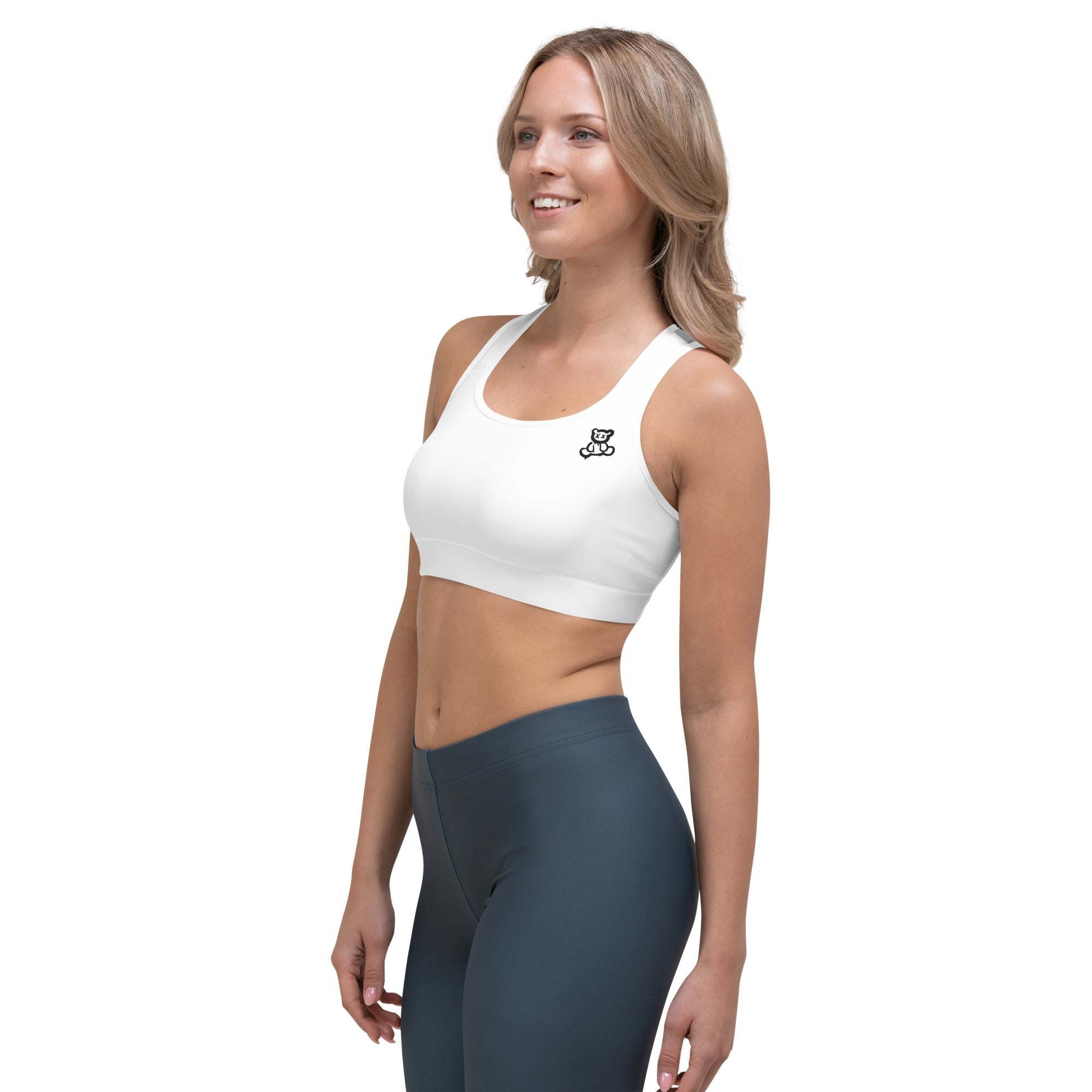 White sports bra with scoop neckline and racerback design, worn by model, ideal for activewear.